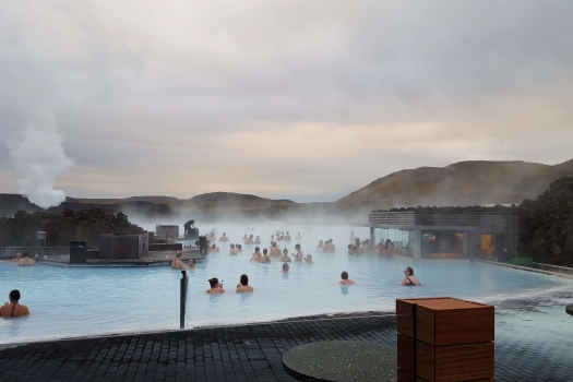 People relaxing in the Blue Lagoon as steam rises from the water