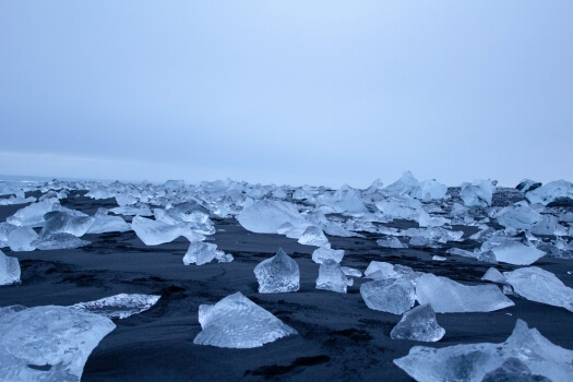 Crystal clear ice on a black sand beach known as Diamond Beach.